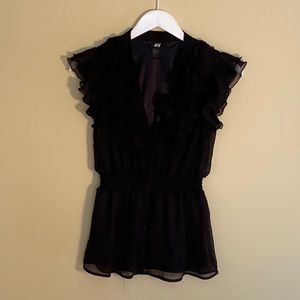 Black ruffled short sleeve shirt wears well with skirts or dressy shorts.